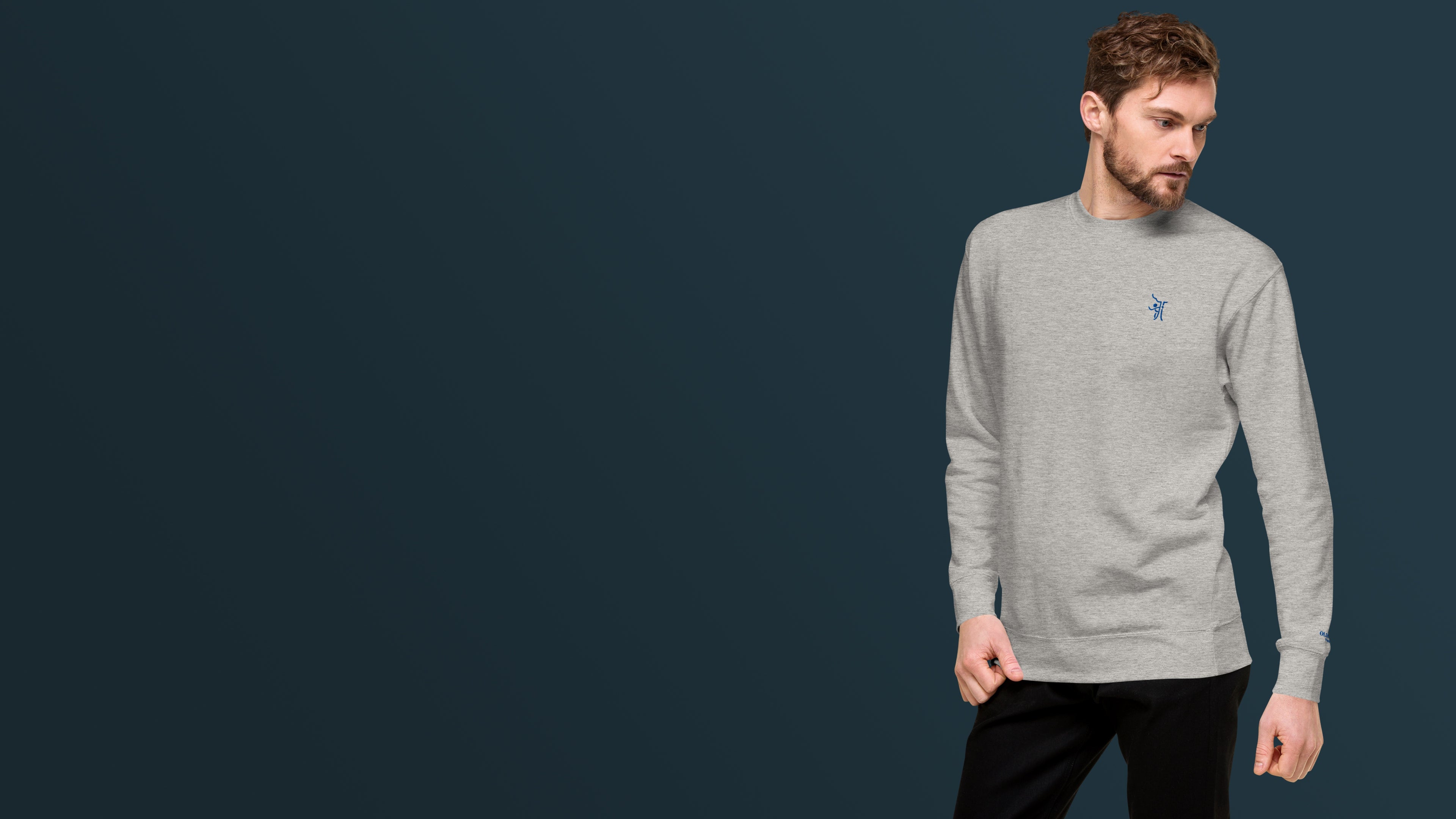 OT Essential Autumn Pullover, Vorderansicht männliches Model trägt simplen Grauer Pullover, Model auf rechter Seite mit dunkelblauem Hintergrund